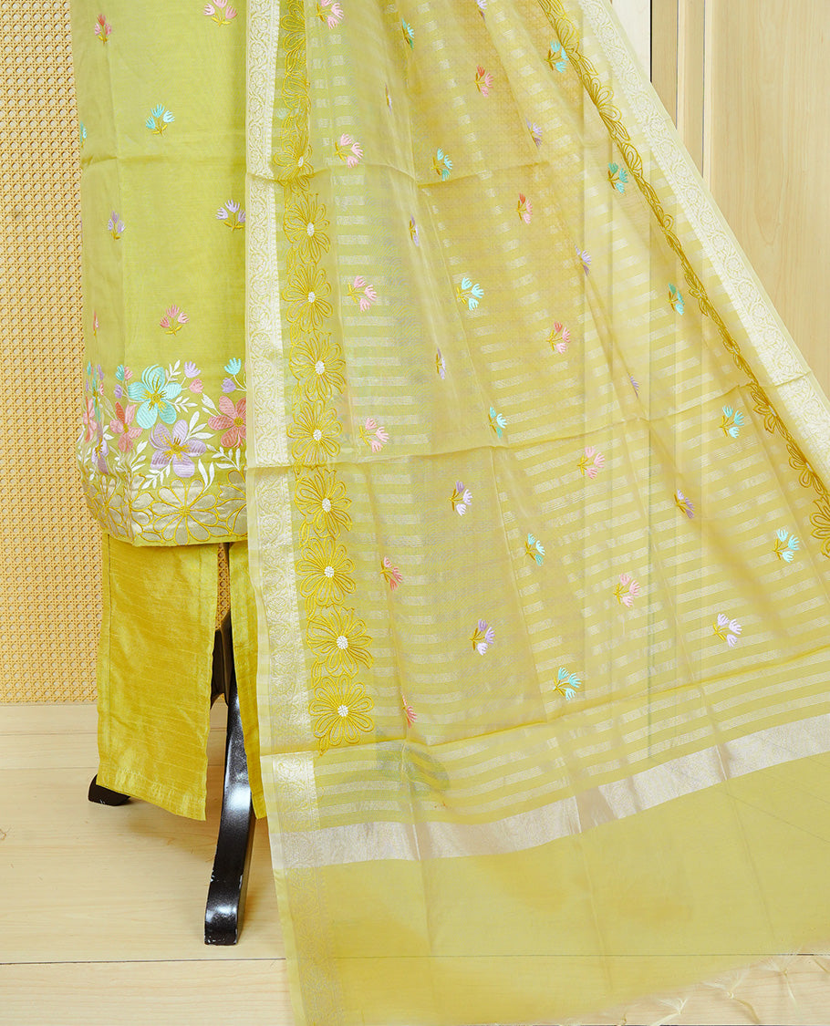 Lemon green colour churidar set with a beaded V-neckline, pastel floral buti embroidery and floral hem detailing, paired with a matching embroidered bordered dupatta and solid pants.