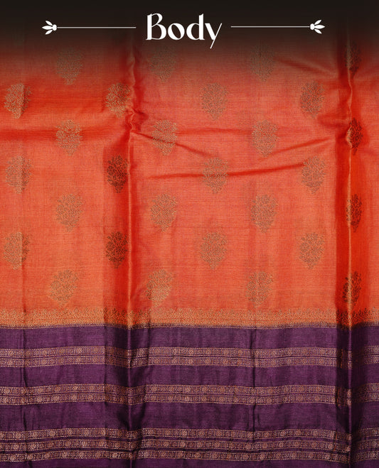 Rust orange colour pure tussar Banaras silk saree featuring elegant gold zari motifs across the body, complemented by a contrast Purple border with rich zari detailing. Comes with a matching blouse piece