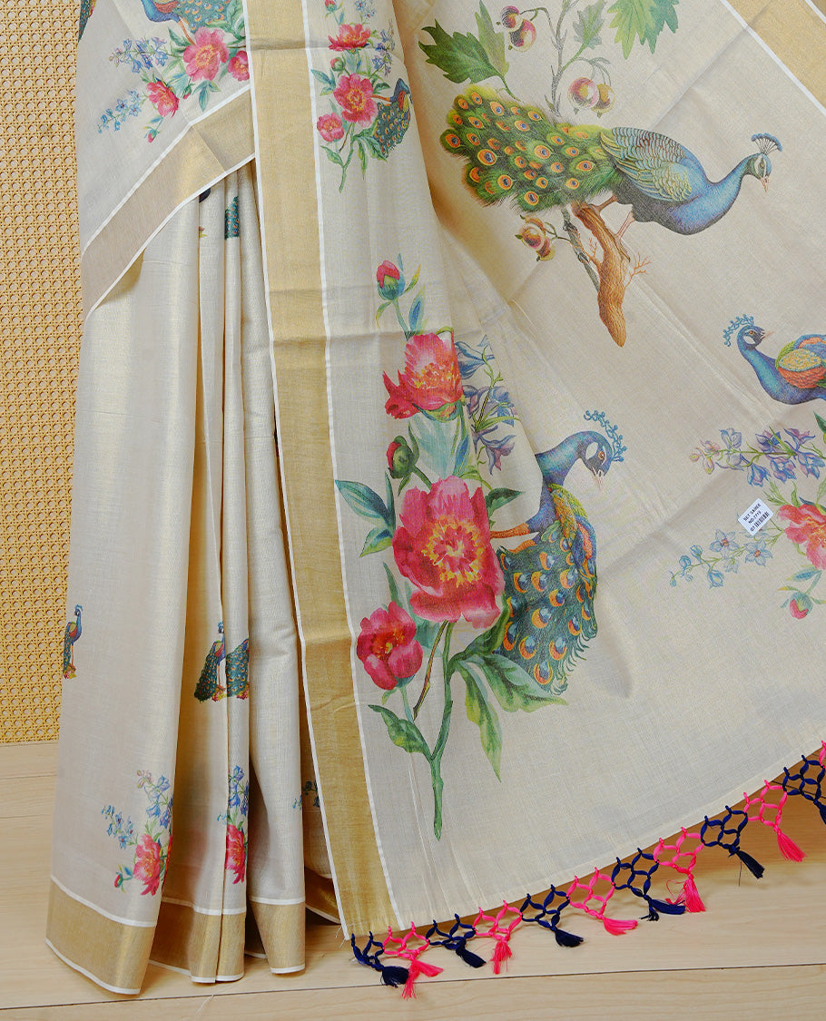 Cream Colour Tissue Kerala  Saree Featuring A Digital  Peacock & Floral Printed Body &  Pallu ,  Beautifully Enhanced With A Classic Gold Zari Border And  Blue & Baby Pink Tassels, Paired With A Matching Blouse Piece