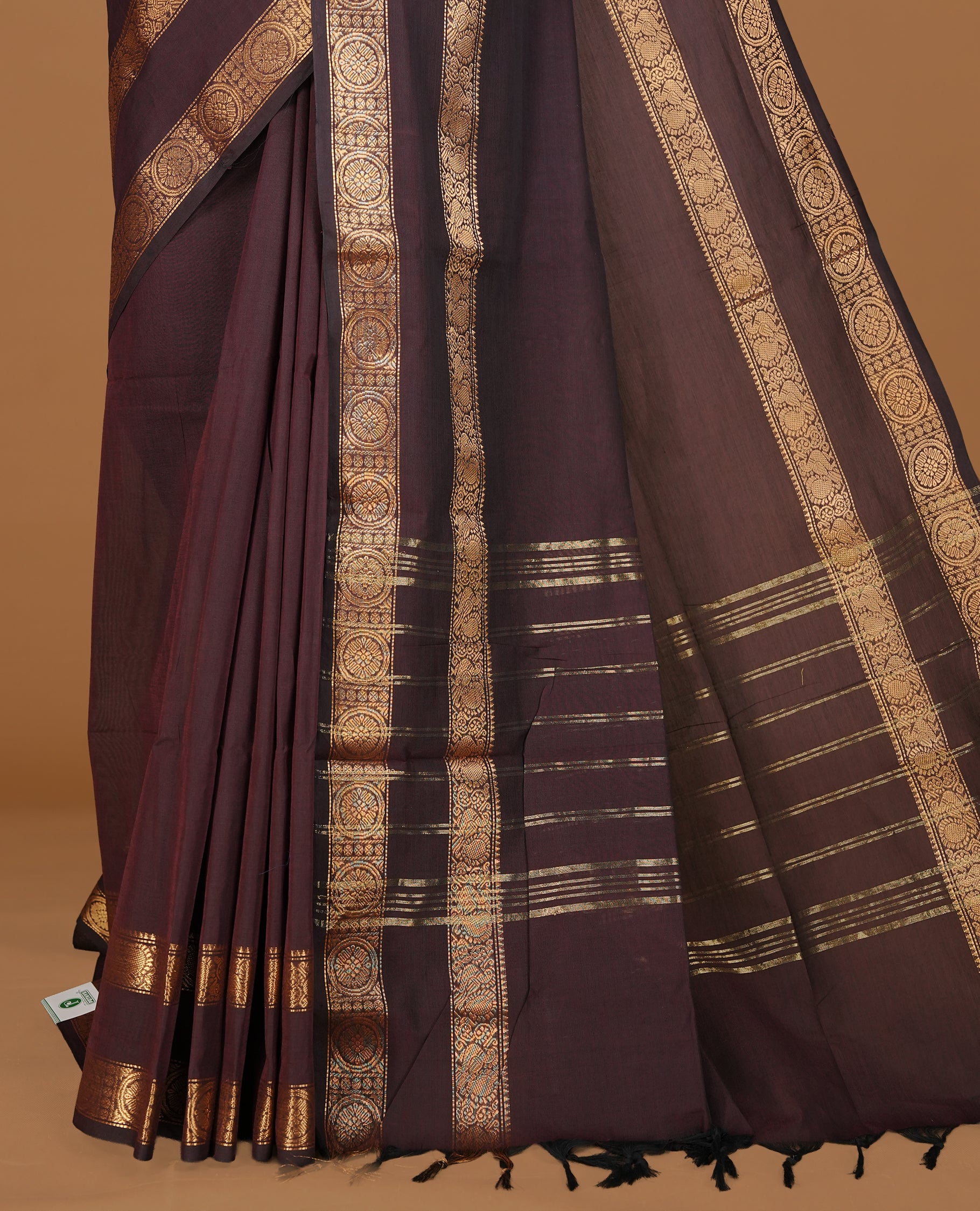 Dark chocolate colour Chettinad cotton saree featuring Elegant plain body, complemented by self colour with gold zari border, paired with matching blouse piece.