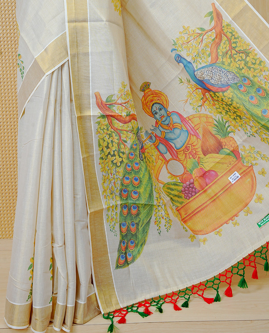 Cream Colour Tissue Kerala Saree Featuring A Digital Vishu Theme At Body & Pallu, Beautifully Enhanced With A Classic Gold Zari Border And  Green & Red  Tassels Paired With A Matching Blouse Piece.