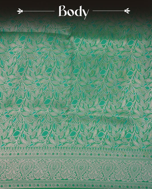 Sea Green Colour Softie Silk Saree Featuring An All Over Gold Woven Leaf Pattern, Finished With A Matching Border Adorned With Intricate Paisley And Floral Motifs, Paired With A Matching Blouse Piece.
