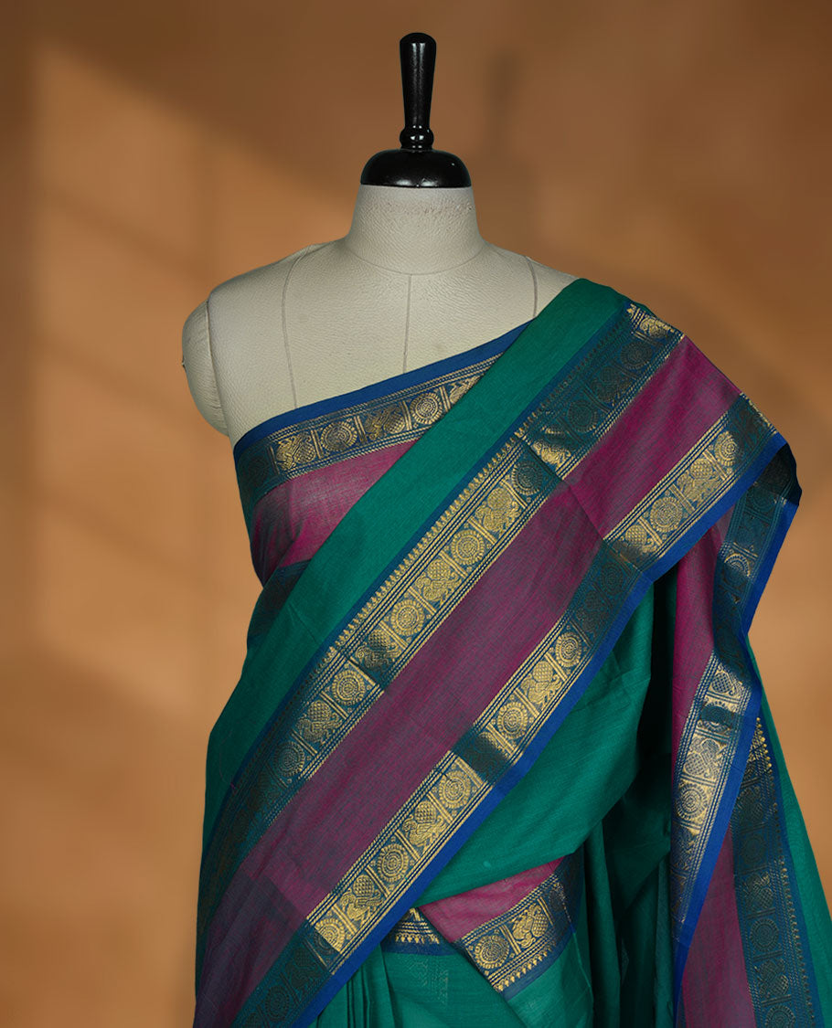 Green colour chettinad cotton saree featuring Elegant plain body highlighting contrast magenta and blue colour with gold zari traditional border, pallu and paired with matching blouse piece.