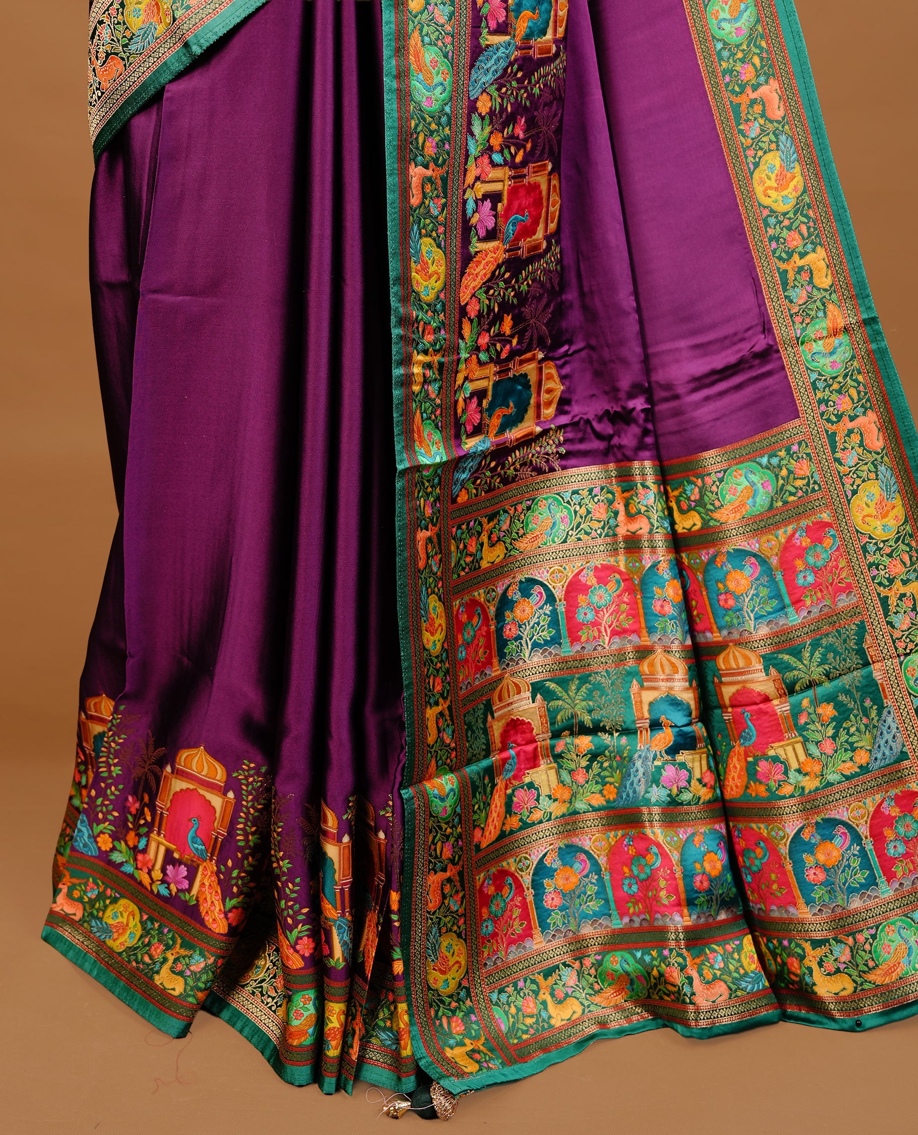 Purple colour Pashmina Saree featuring elegant woven temple and floral motifs, enhanced with a contrast green woven border and a richly detailed traditional pallu, paired with a matching blouse piece.