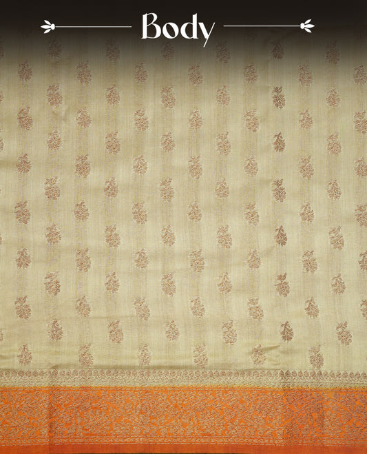 Cream colour pure tussar Banaras silk saree featuring intricate gold zari motifs across the body, enhanced with a contrast orange floral kodi zari border for a rich traditional look. Comes with a matching blouse piece.