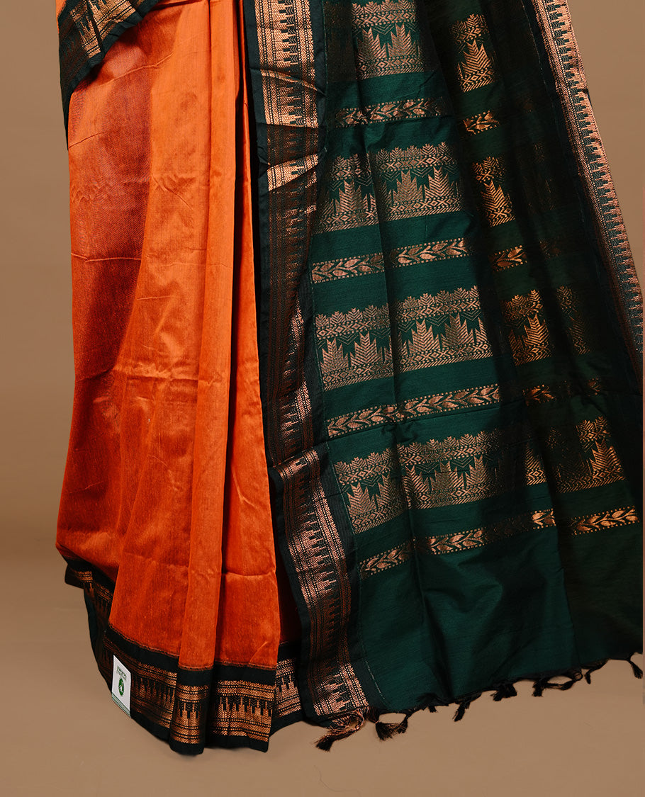 Orange colour kalyani cotton saree featuring gold zari motifs on body, highlighting contrast green colour with Antique gold zari border, paired with matching blouse piece.