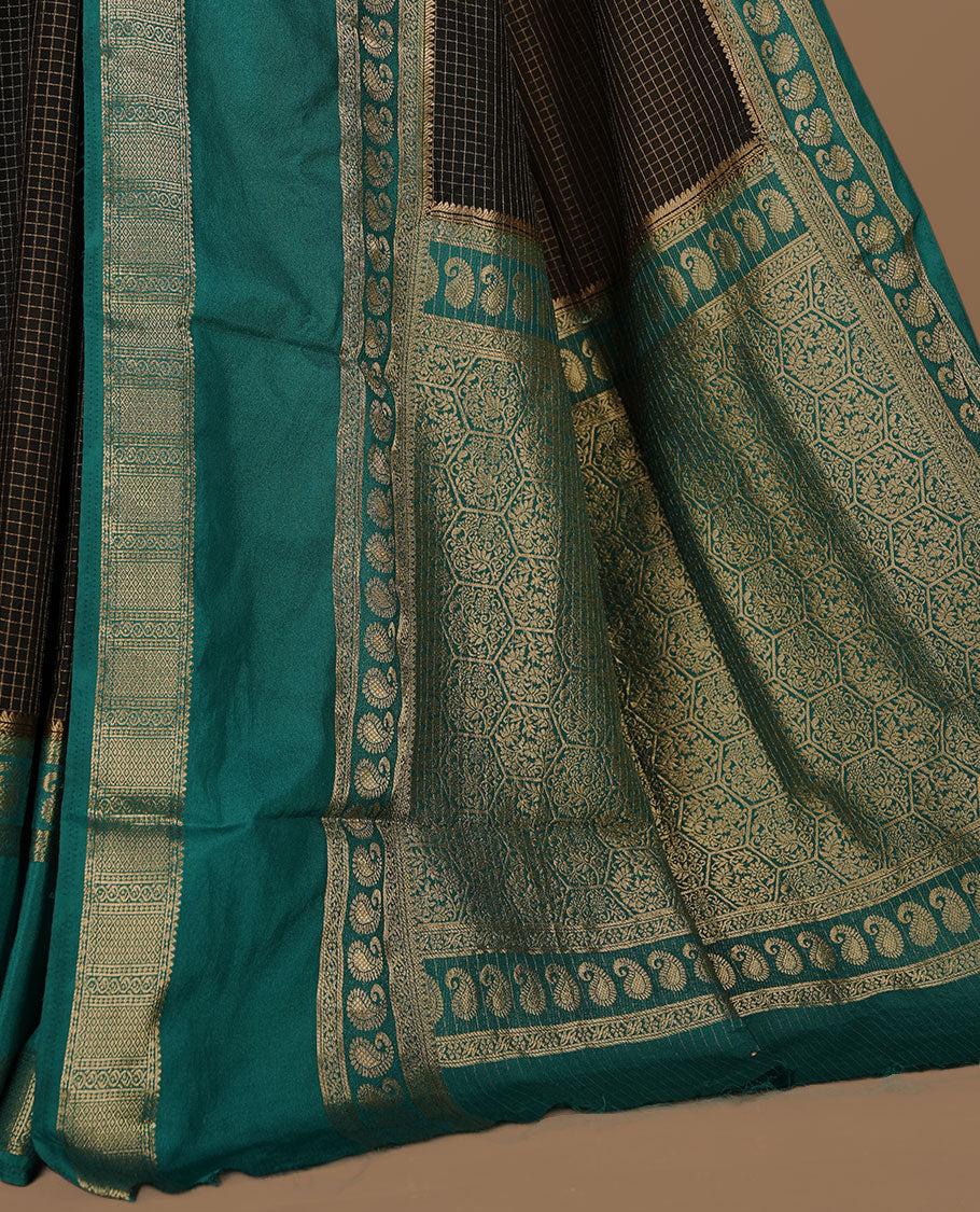 Black colour semi georgette saree featuring gold zari check pattern on body, complemented by contrast green colour with zari border, paired with matching blouse piece.