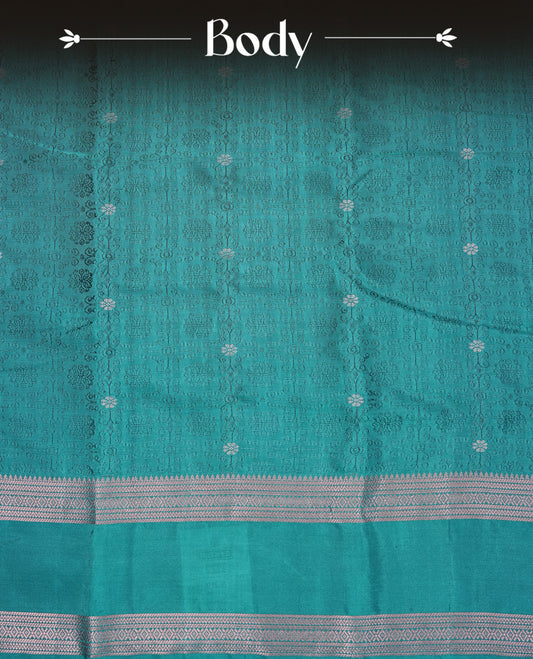 Teal Green Colour  Semi Soft Slik  Saree Featuring An Elegant Self Floral Woven Body, Enhanced By A Traditional Rose Gold Zari Border And Rich Pallu, Paired With A Matching Blouse Piece.