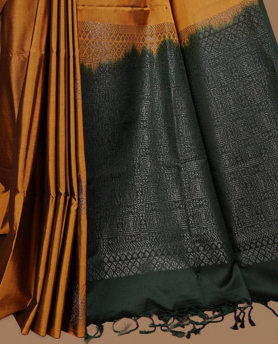 Mustard colour soft silk saree features a sleek borderless design with intricate antique zari motifs, flowing into a striking contrast dark green pallu and a matching blouse piece.