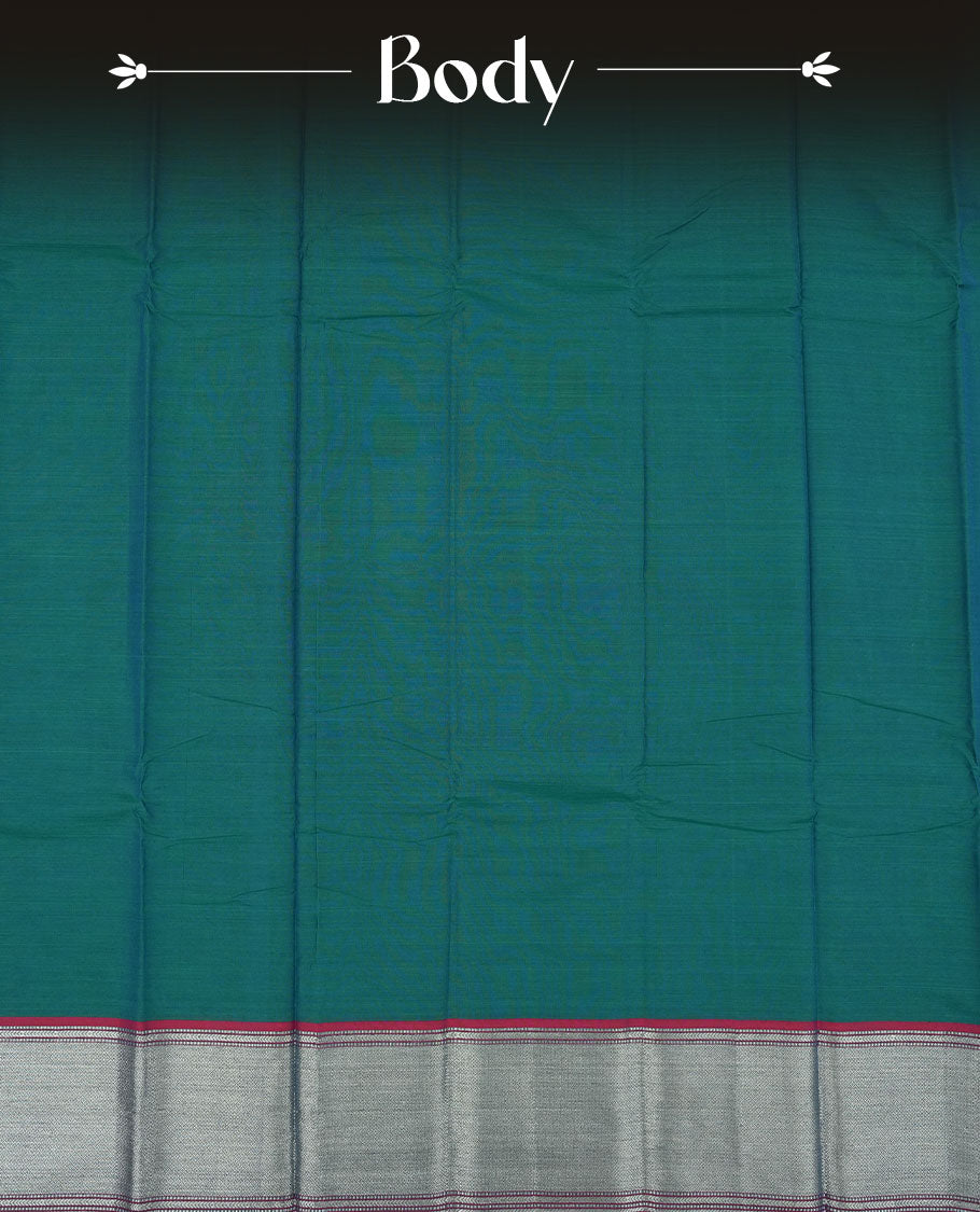 Peacock colour Narayanapattu cotton saree featuring a self coloured body, contrast deep red colour with silver zari border and pallu, pairing a matching blouse piece.