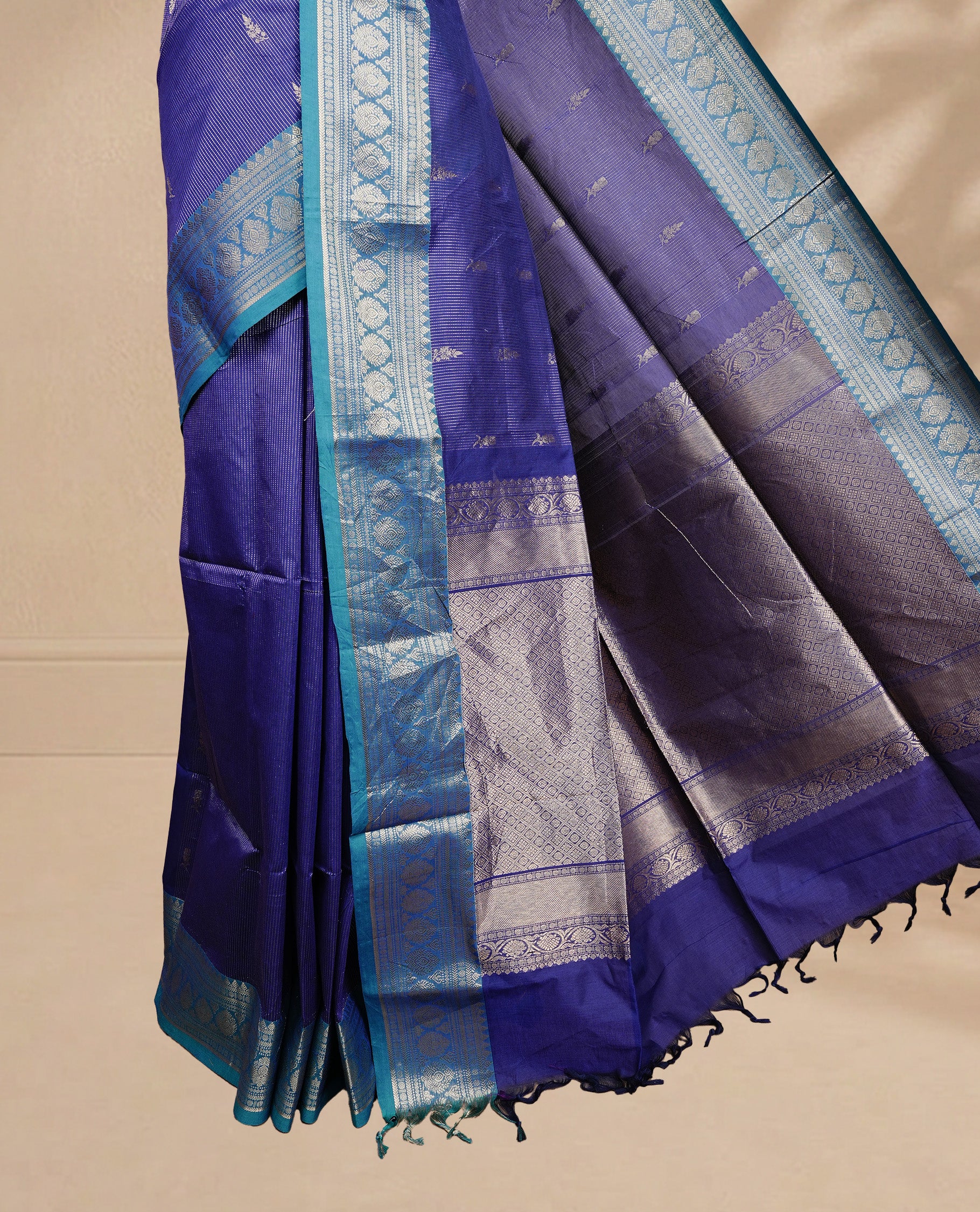 Navy blue colour chettinad cotton saree featuring gold zari stripes & motifs on body, complemented by Contrast Teal colour with zari border, paired with matching blouse piece.