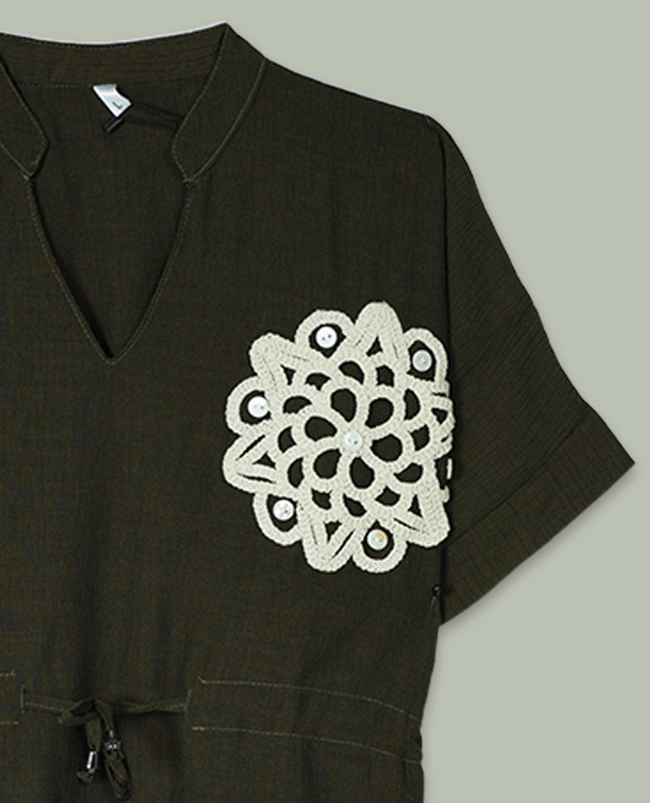 Olive green short-sleeve top with V-slit band neckline, contrast ivory crochet motif on one side, and adjustable drawstring detail at the waist.