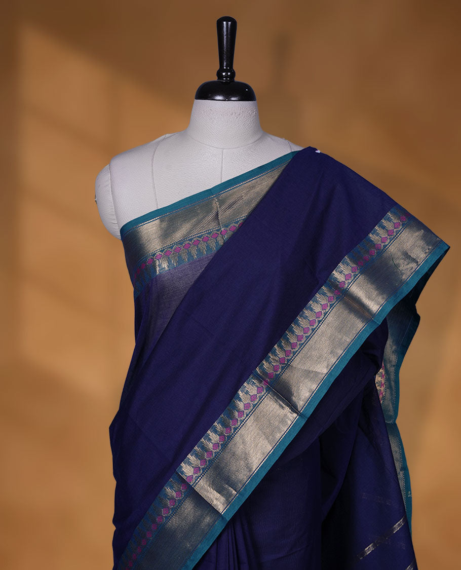 Navy Blue colour chettinad cotton saree featuring Elegant plain body, contrast green colour border with gold zari border, pallu and paired with matching blouse.
