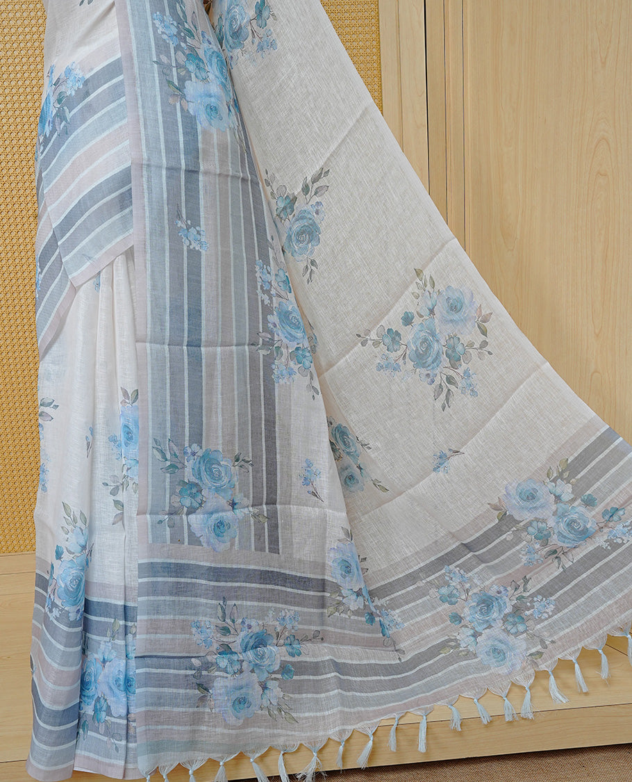 Cream colour semi linen saree featuring Blue colour floral print on body, complemented by contrast Strip pattern border, comes with matching blouse piece.