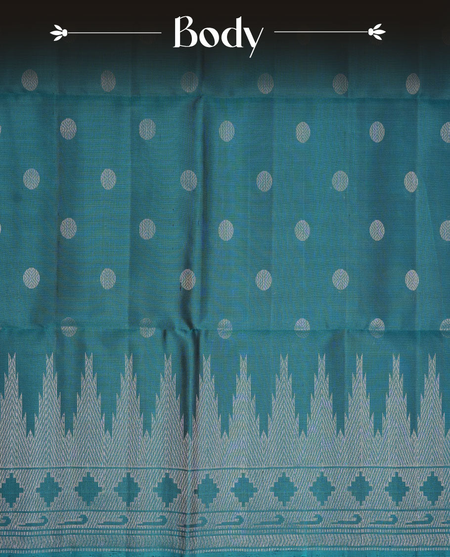 Teal colour soft silk saree featuring silver zari motifs on body, complemented by self colour with traditional border with tassel at pallu, paired with matching blouse piece.