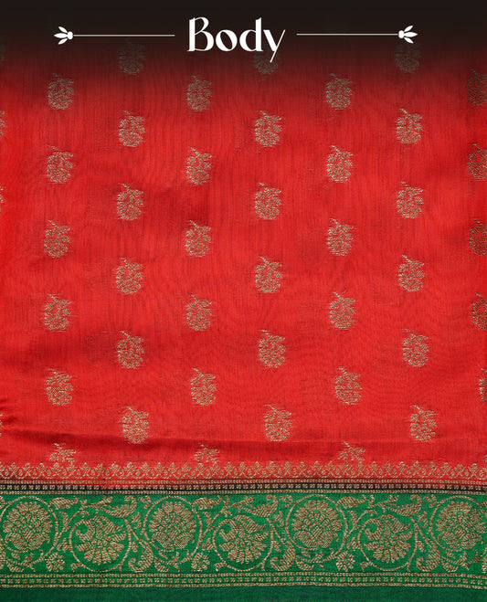 Red colour pure tussar Banaras silk saree featuring intricate gold zari motifs across the body, enhanced with a contrast green floral kodi zari border for a rich traditional look. Comes with a matching blouse piece.