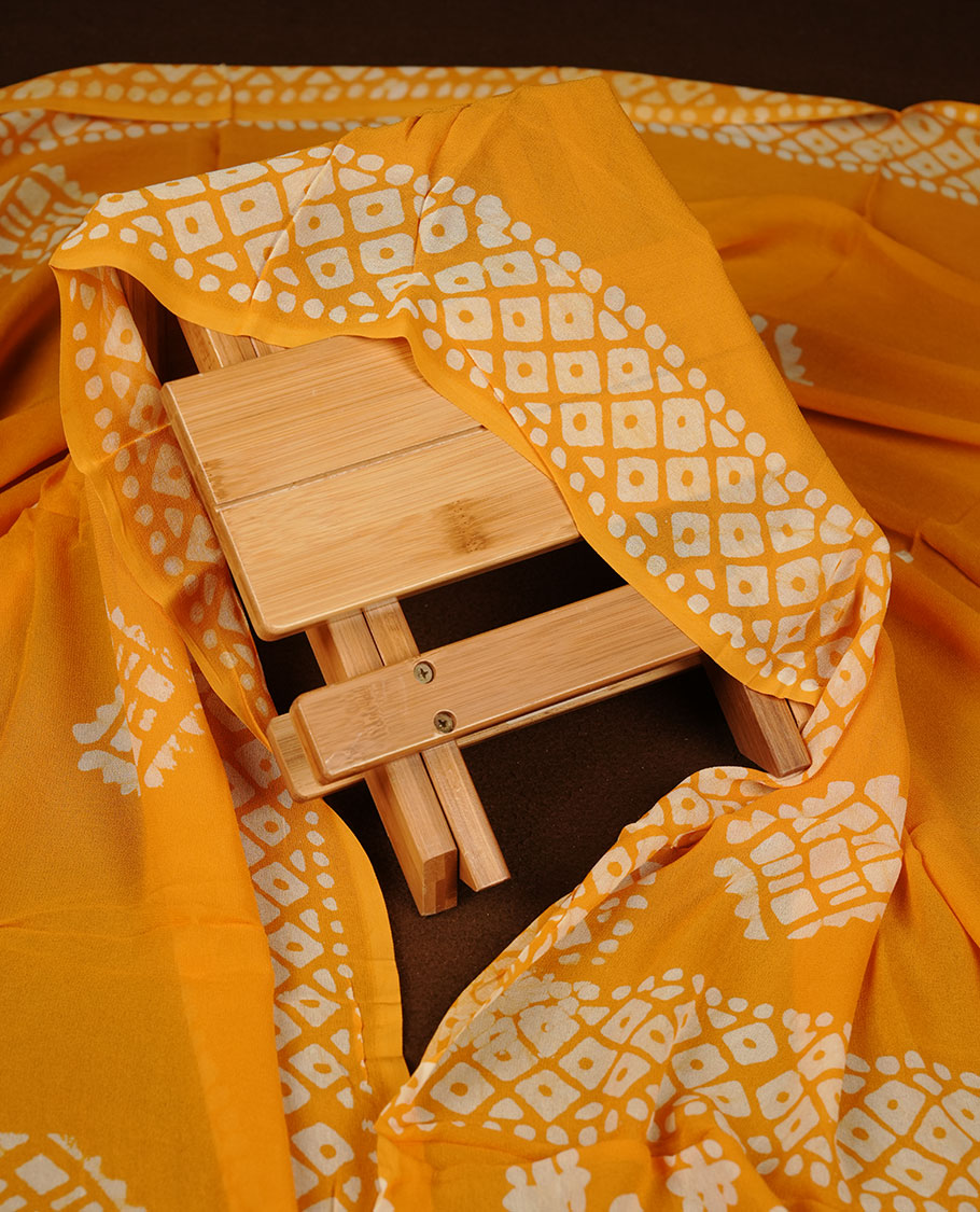 Yellow orange colour churidar material featuring elegant gold butta work on the front panel, paired with a printed dupatta and matching bottom.