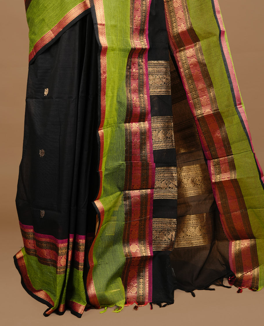 Black colour chettinad cotton saree featuring gold zari motifs on body, complemented by magenta & green colour with zari border, paired with matching blouse piece.