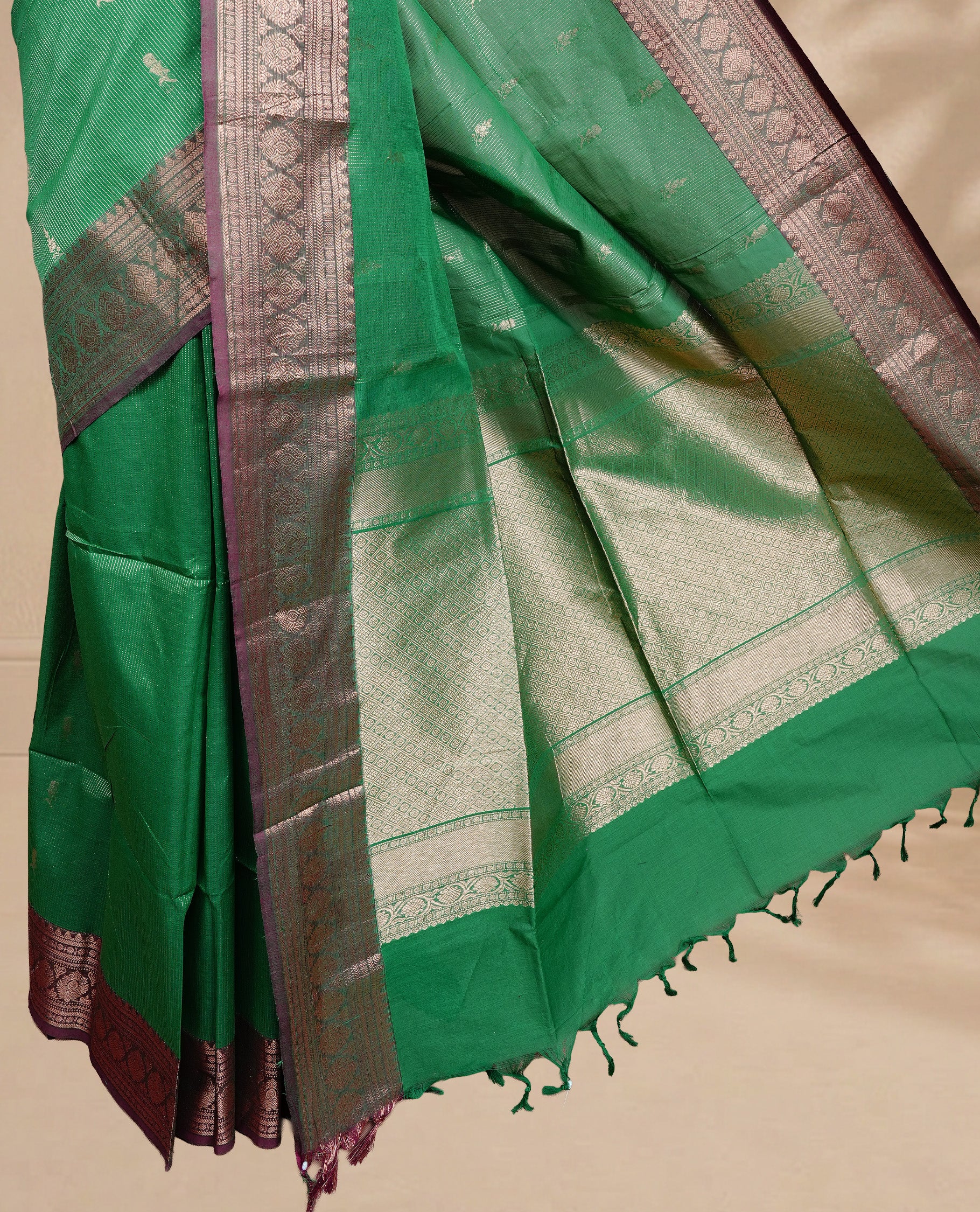 Green colour chettinad cotton saree featuring gold zari stripes & motifs on body, complemented by Contrast Maroon colour with zari border, paired with matching blouse piece.