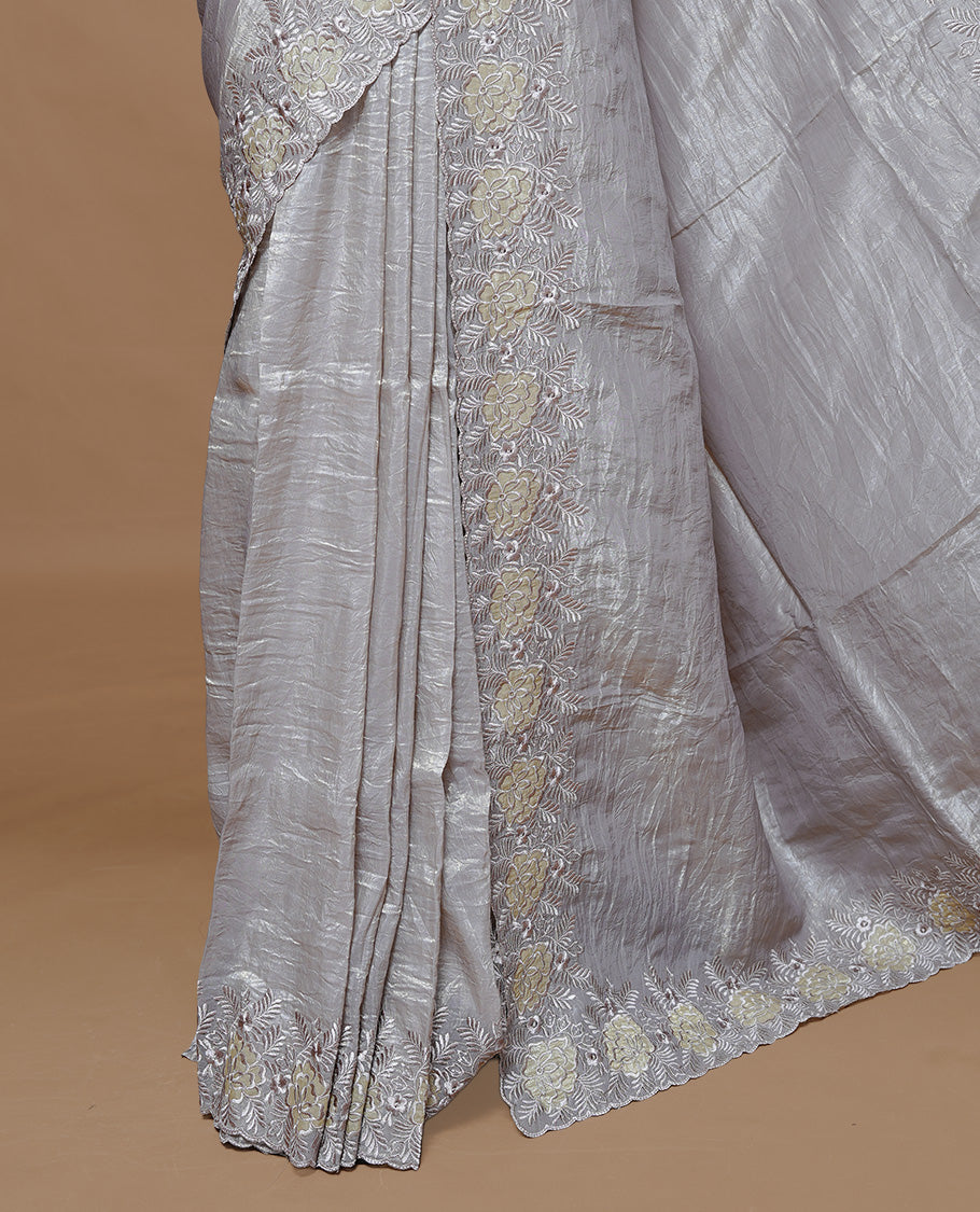 Grey colour Crush Organza Featuring Plain body, Enrich with Floral thread pattern & scalp border, paired with matching blouse piece.