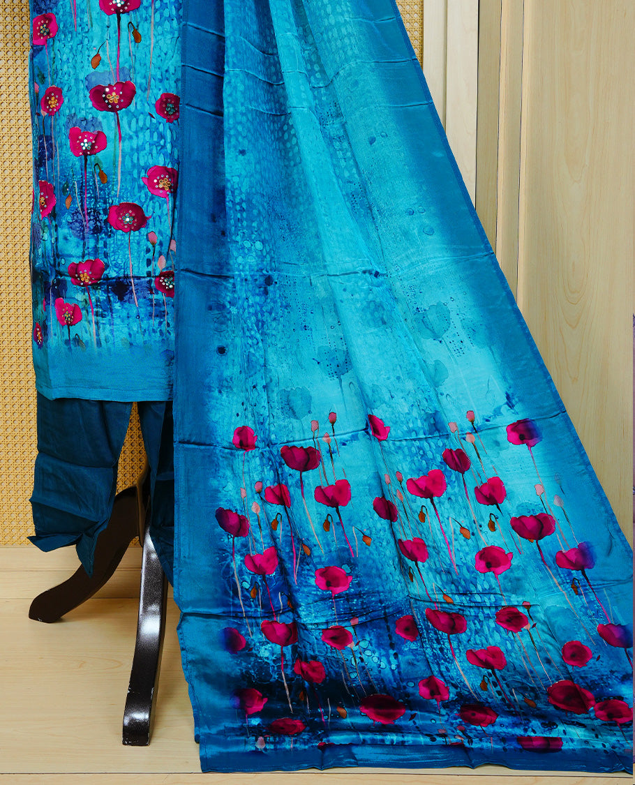 Blue colour churidar set featuring vibrant floral prints and delicate bead work on the V-neckline, paired with matching solid pants and a floral printed dupatta.