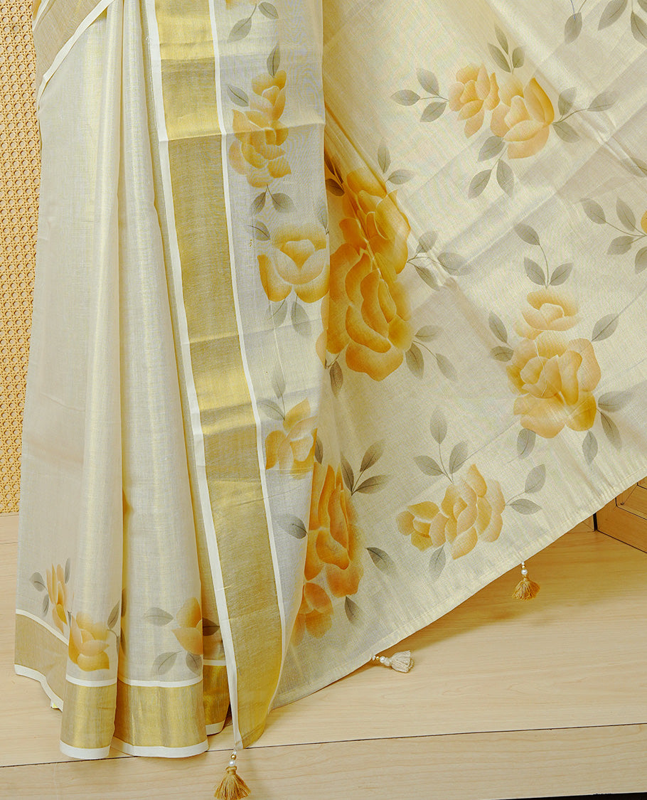 Cream Colour Tissue Kerala Saree Featuring Digital Mustard Yellow Rose Prints Across The Body, Enhanced With A Gold Zari Border , Finished With Light Brown & Cream Tassels And A Matching Blouse Piece