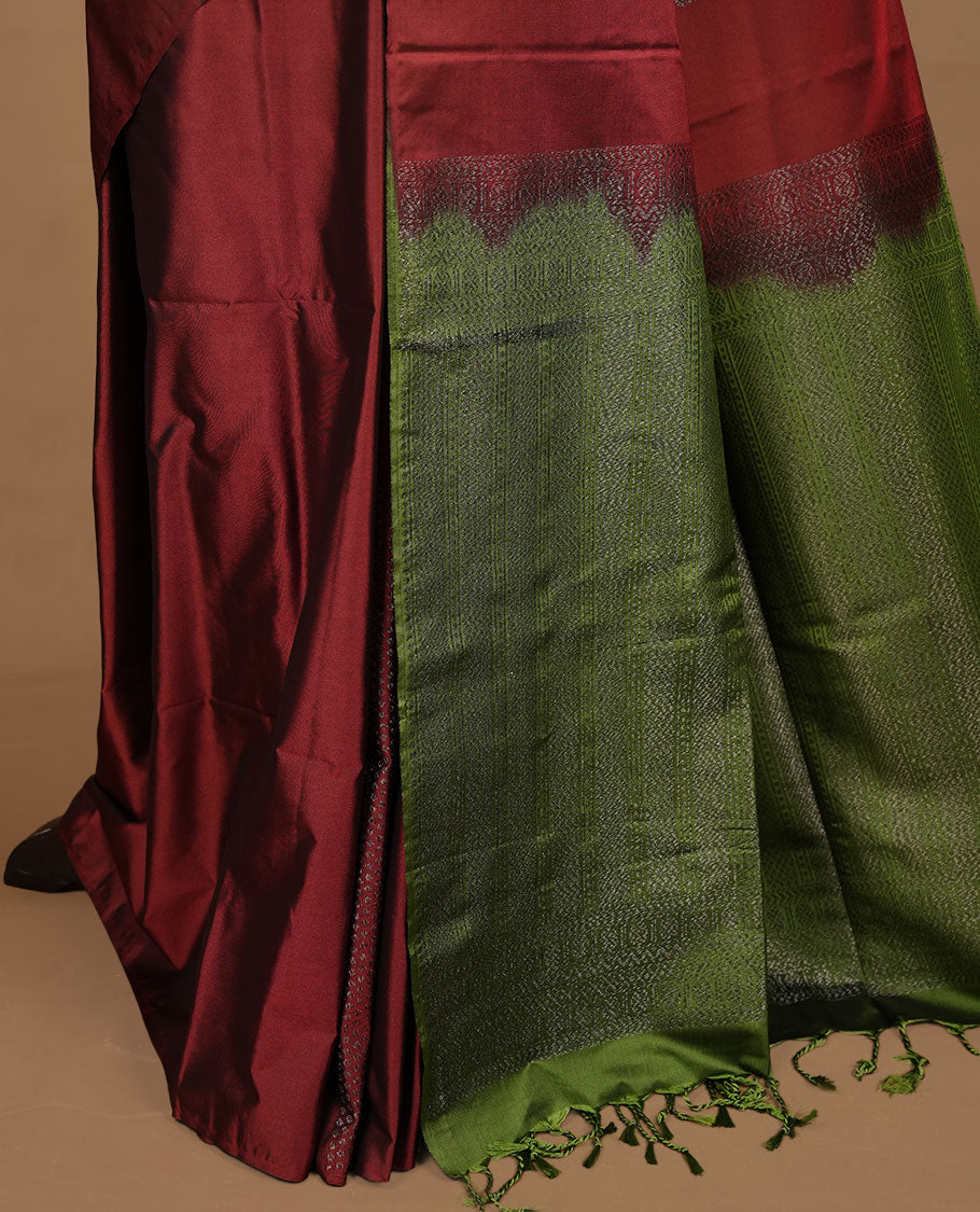 Brown colour soft silk saree features a sleek borderless design with intricate antique zari motifs, flowing into a striking contrast green pallu and a matching blouse piece.