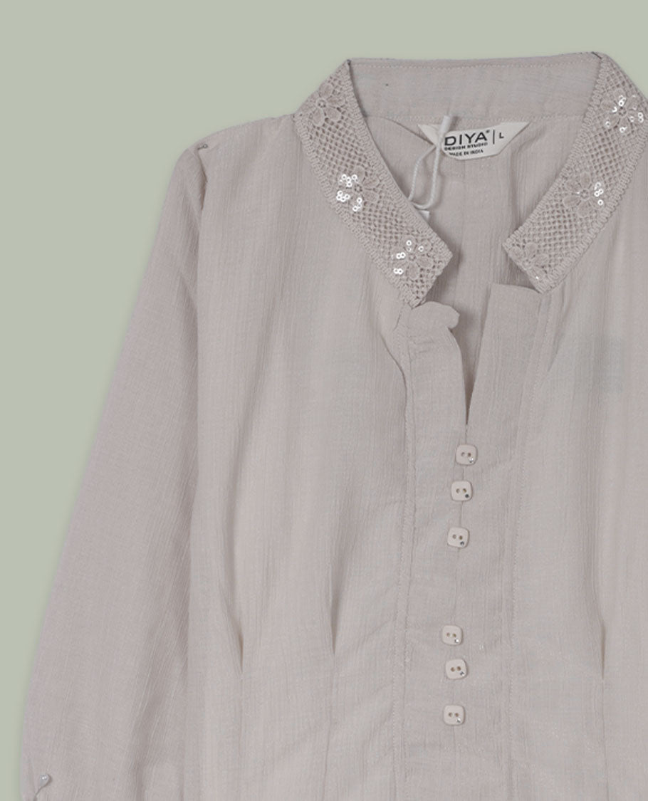 Cream three-quarter sleeve shirt top with embellished band collar and cuffs, front button placket, and soft pleating below the placket.