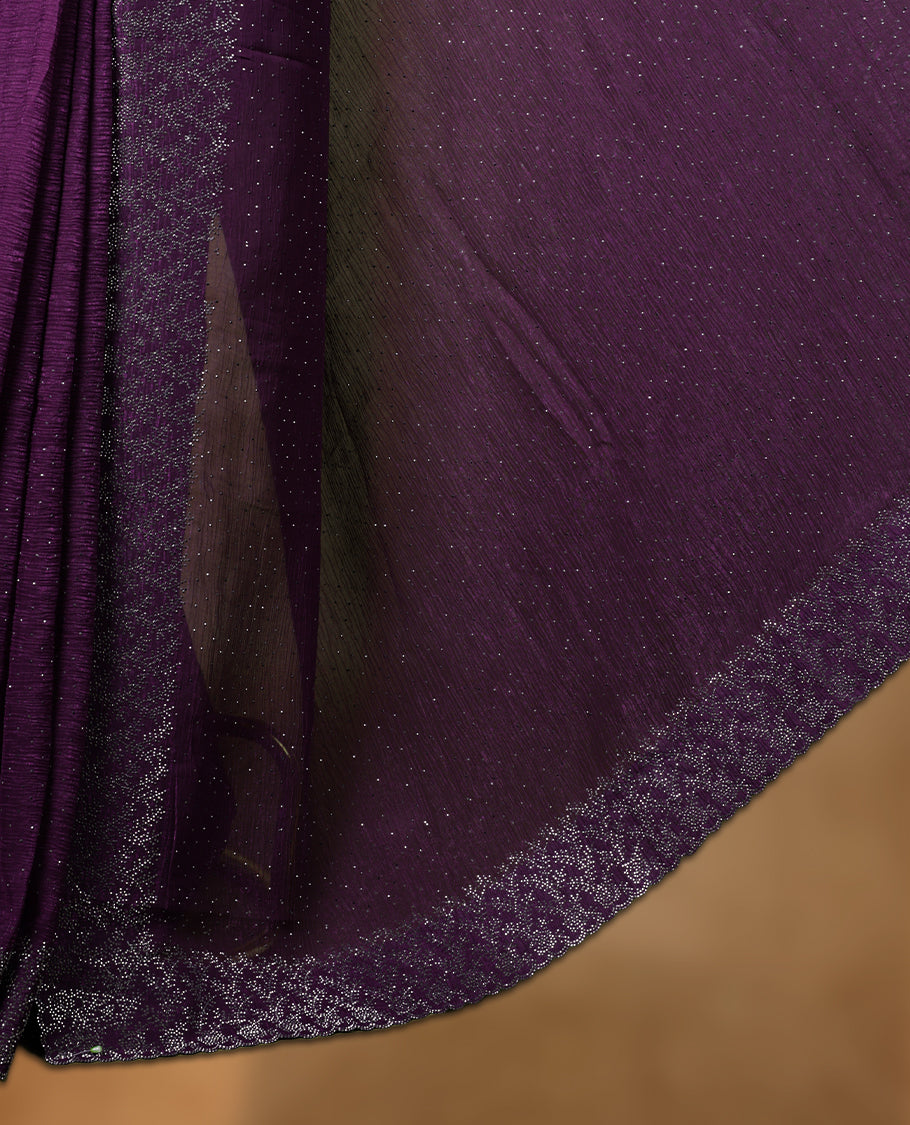 Dark purple colour chiffon designer saree, featuring white stone all over on body, heavy stone patttern on border and  pallu, Paired with matching blouse.