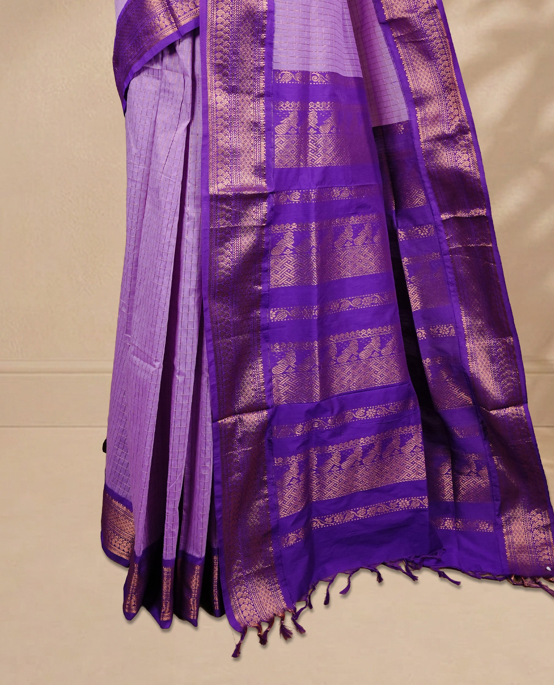 Lavender colour kalyani cotton saree featuring gold zari check pattern on body, complemented by Violet colour with Antique zari border, paired with matching blouse piece.