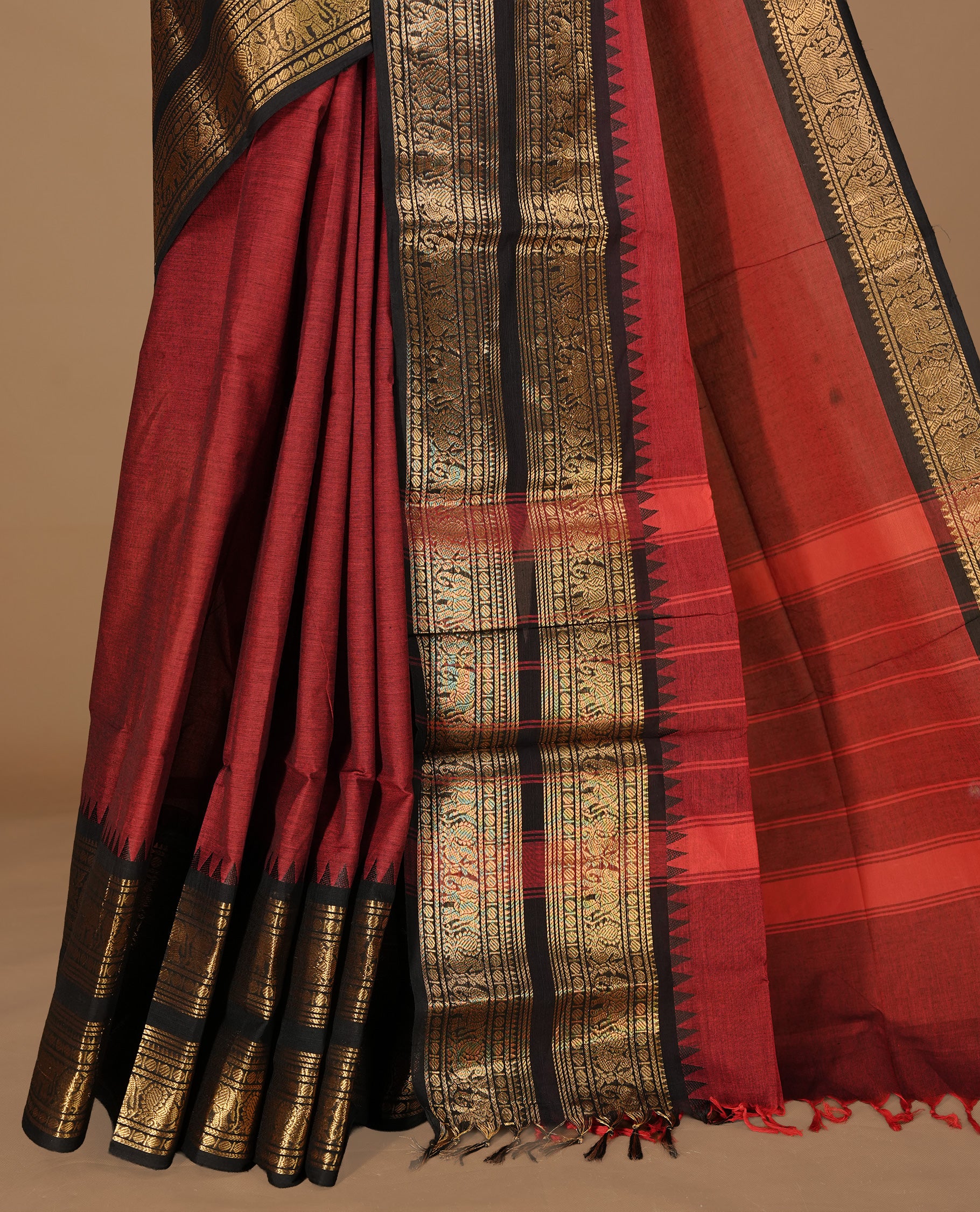 Red colour Chettinad cotton saree featuirng Elegant Plain body, complemented by contrast black colour with gold zari border, paired with matching blouse piece.