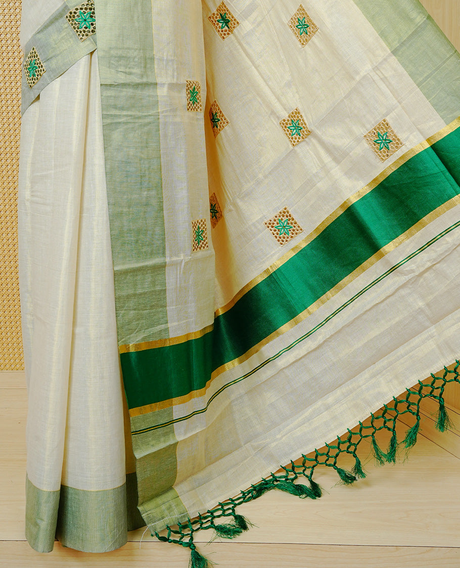 Cream Colour Tissue Kerala Saree Featuring Delicate Green  Floral Embroidery Work Across The Body, Enhanced With A Light Green  Zari Border And A Rich Green & Gold Zari Pallu, Finished With Green Tassels And A Matching Blouse Piece