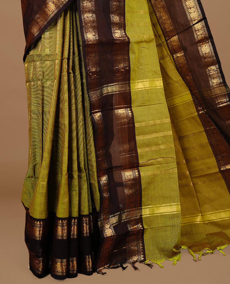 Olive colour chettinad cotton saree featuring gold zari stripes on body, complemented by dark chocolate colour with zari border, paired with matching blouse piece.