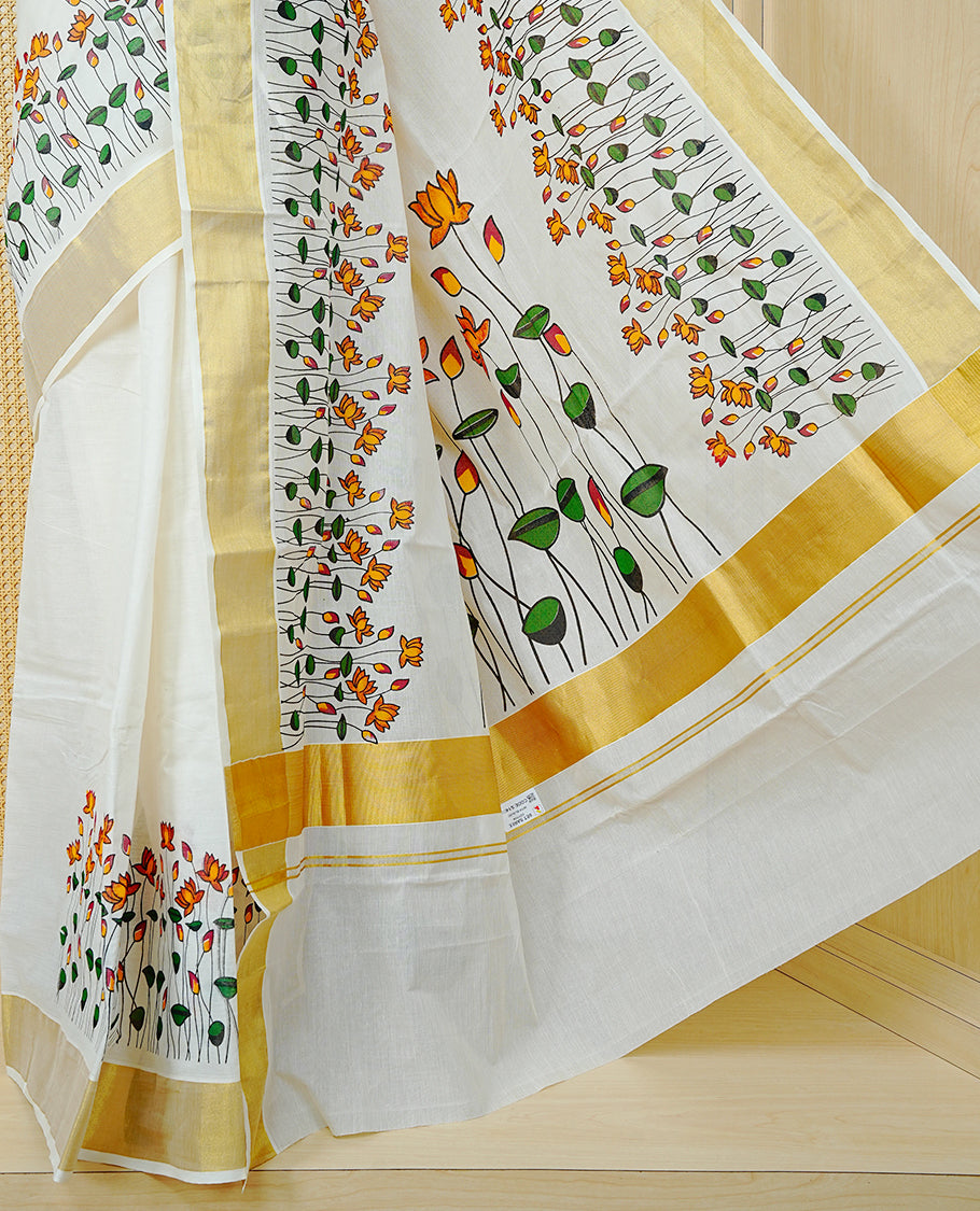 Cream Colour Cotton Kerala Saree Featuring Floral And Lotus Motifs On Body, With A Classic Gold Zari Border & A Gold Zari Pallu, Paired With A Matching Blouse Piece.