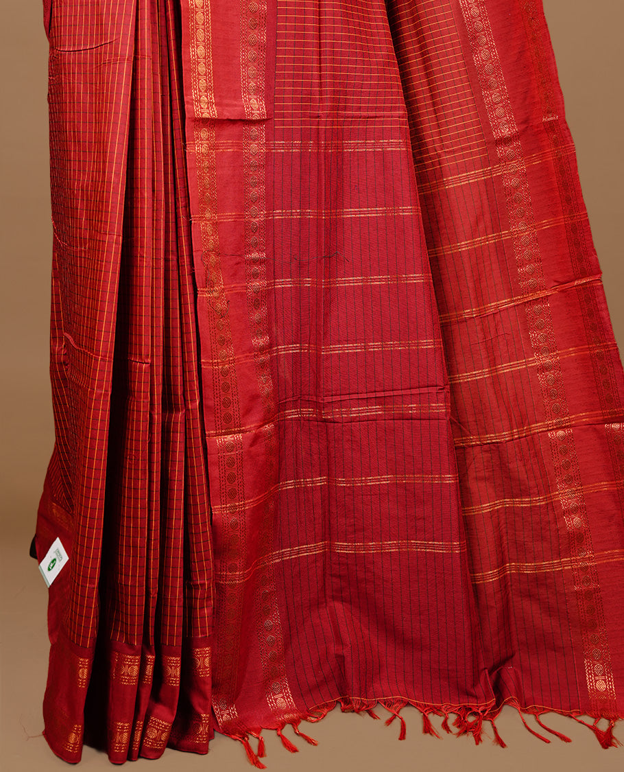 Red colour kalyani cotton saree featuring check pattern on body, highlighting self colour with simple gold zari border, paired with matching blouse piece.
