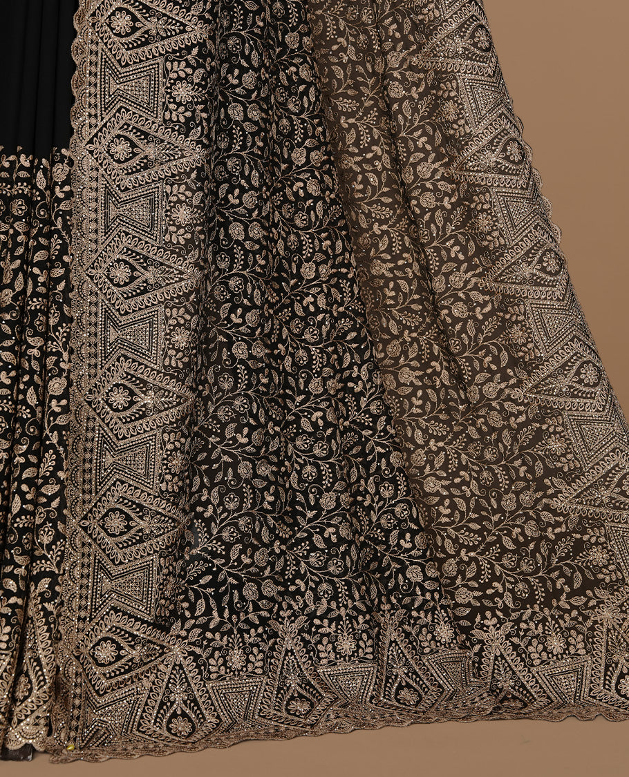 Black colour georgette designer saree featuring Gold thread floral pattern on body highlighting with stone and scalp border, paired with matching blouse piece.