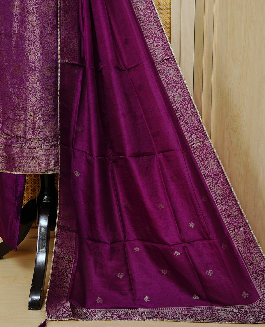 Royal purple churidar set with an ornate embellished round neckline, floral zari pattern, paired with a matching dupatta featuring zari butis and an intricate border & solid pants.