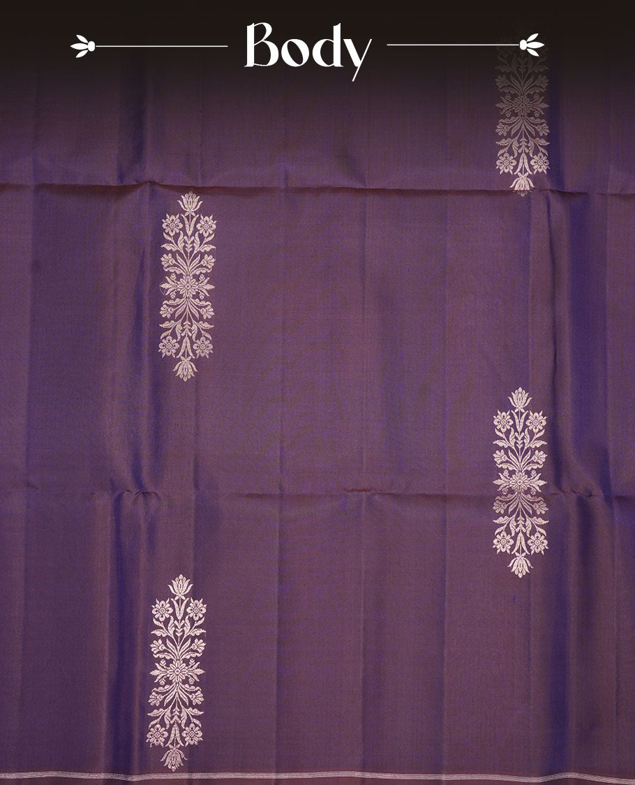 Plum purple colour soft silk saree featuring gold zari motifs on body, complemented by self colour with traditional border with tassel at pallu, paired with matching blouse piece.