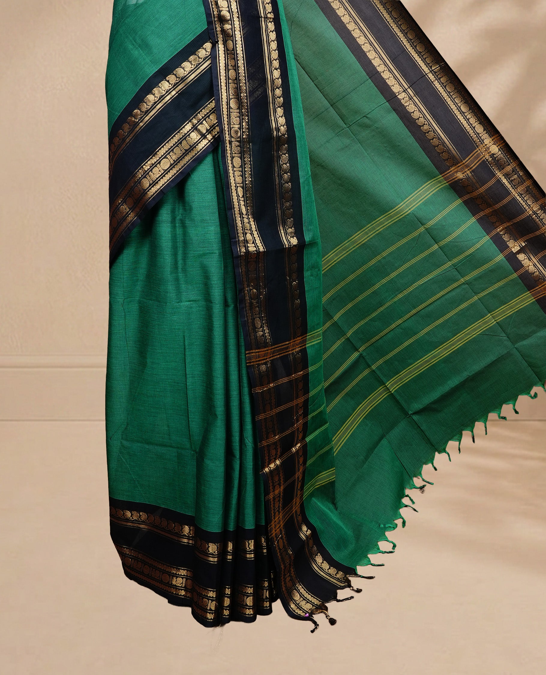 Green colour chettinad saree featuring Elegant Plain on body, complemented by contrast black colour with Gold zari border, paired wih matching blouse piece.