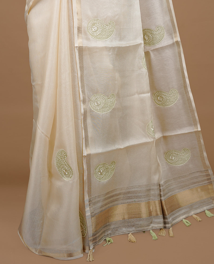 Cream colour Tussar saree featuring Light green colour Mango pattern with chikankari embroidery work, highlighting gold zari simple border, paired with matching unstitched blouse.