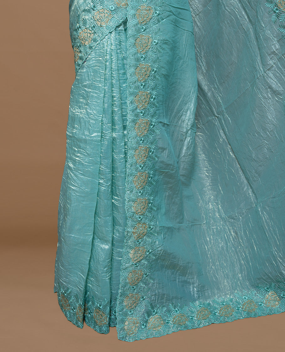Aqua colour Crush Organza Featuring Plain body, Enrich with Floral thread pattern & scalp border, paired with matching blouse piece.