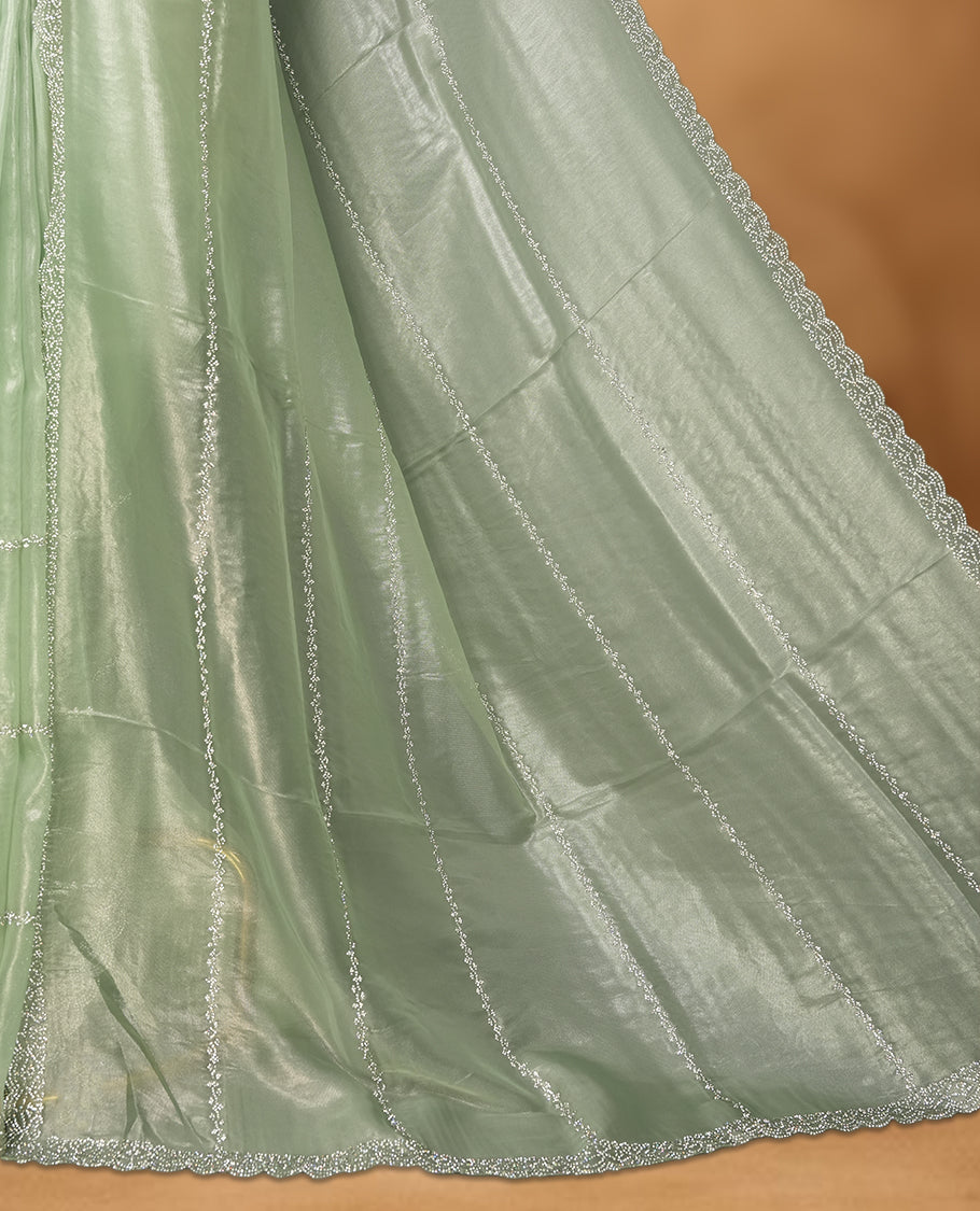 Mint Green Colour net shimmer fancy saree adorned with strip white stone buttas all over the body, paired with a delicate stone worked border and matching blouse