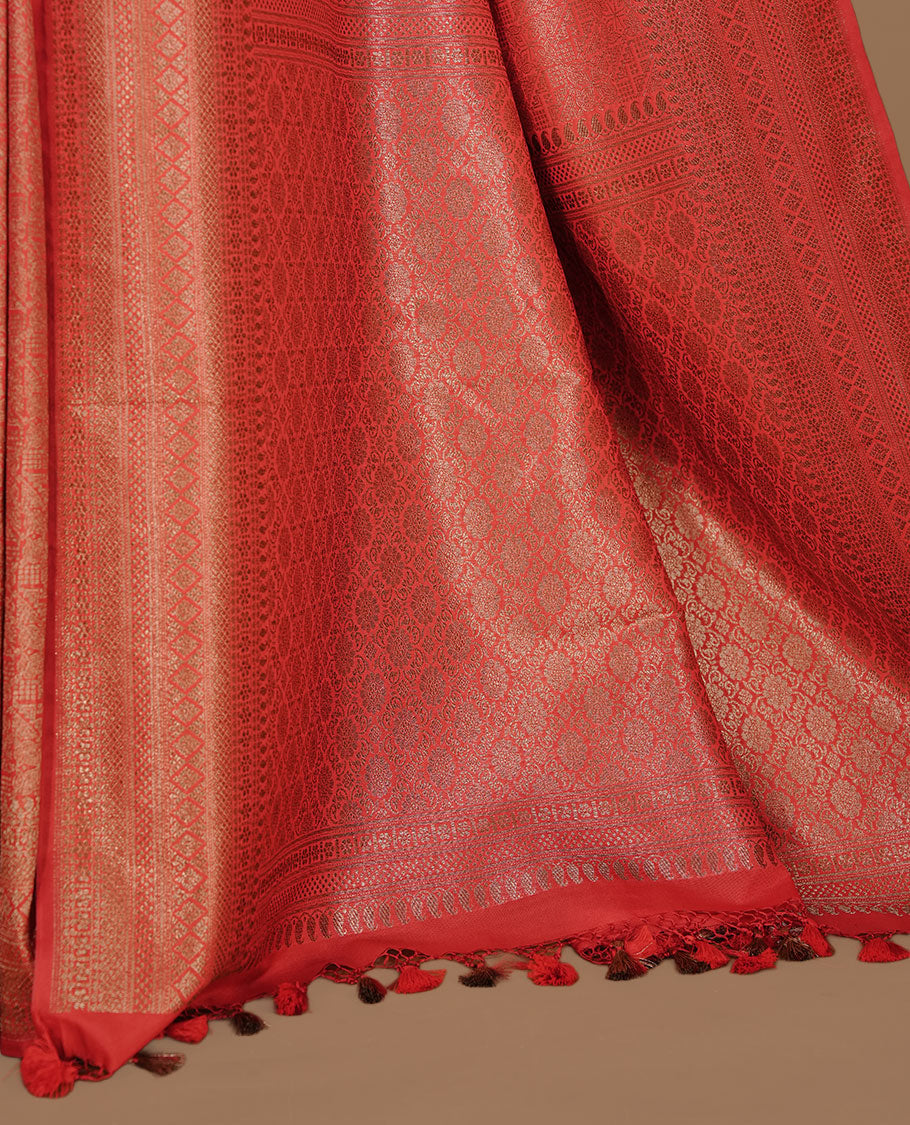 Red colour semi banaras katan saree featuring Gold zari Pattern across body, complemented by self colour with zari border, paired with matching blouse piece.
