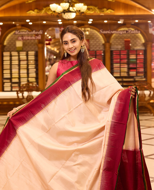 Ivory colour pure kancheepuram silk saree featuring a rich gold zari temple pallu, complemented with a contrast deep red border finished with gold and green selvedge and a matching deep red pallu, beautifully paired with a matching blouse.