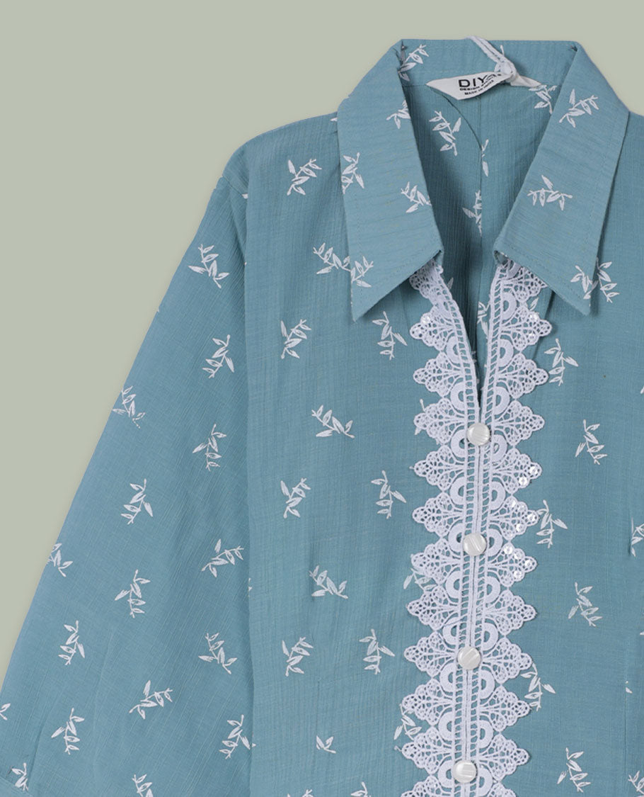 Dusty teal shirt top with all-over tiny white sprig print, collared neckline, three-quarter sleeves, and front button placket framed by a wide scalloped lace panel.