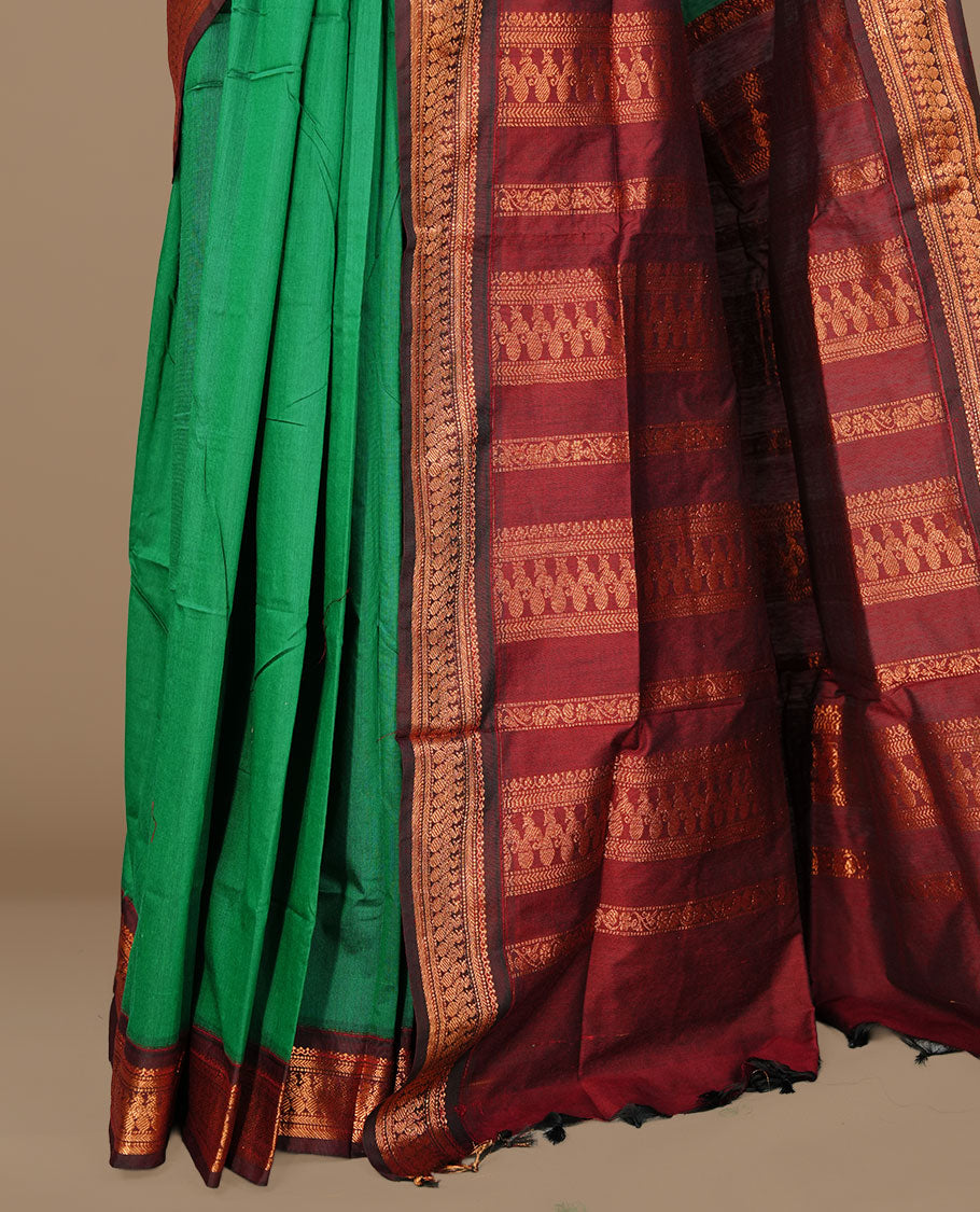 Green colour kalyani cotton saree featuring gold zari motifs on body, complemented by Maroon colour with Antique zari border, paired with matching blouse piece.