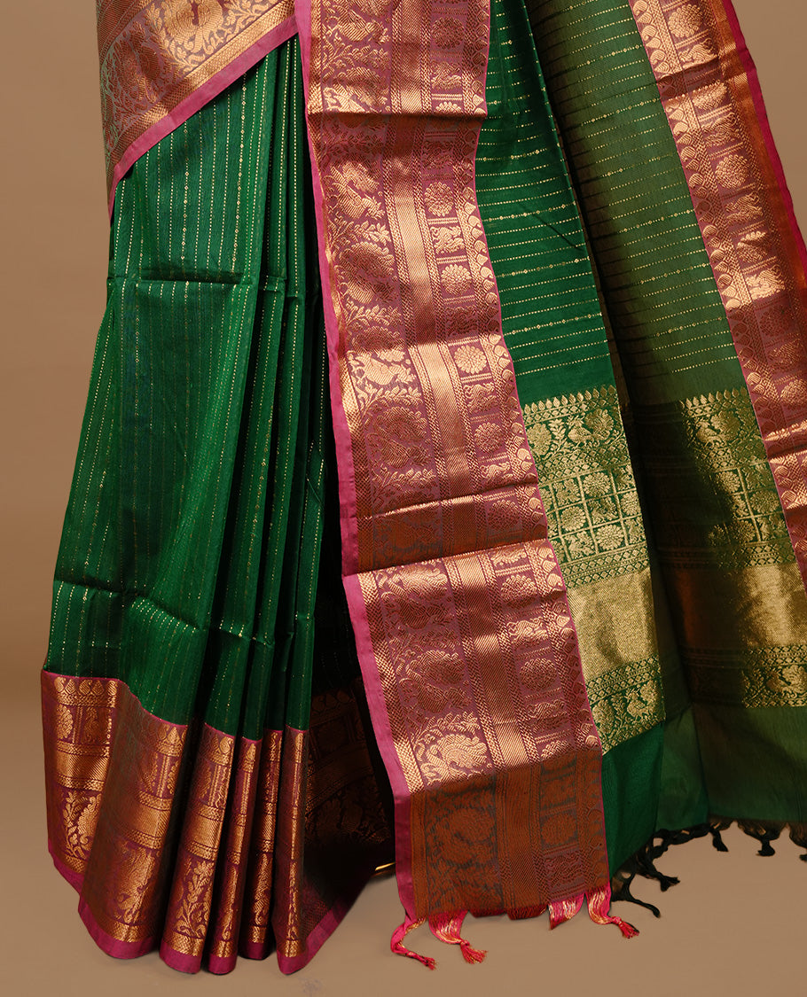 Green colour chettinad cotton saree featuring gold zari stripes on body, complemented by magenta colour with zari border, paired with matching blouse piece.