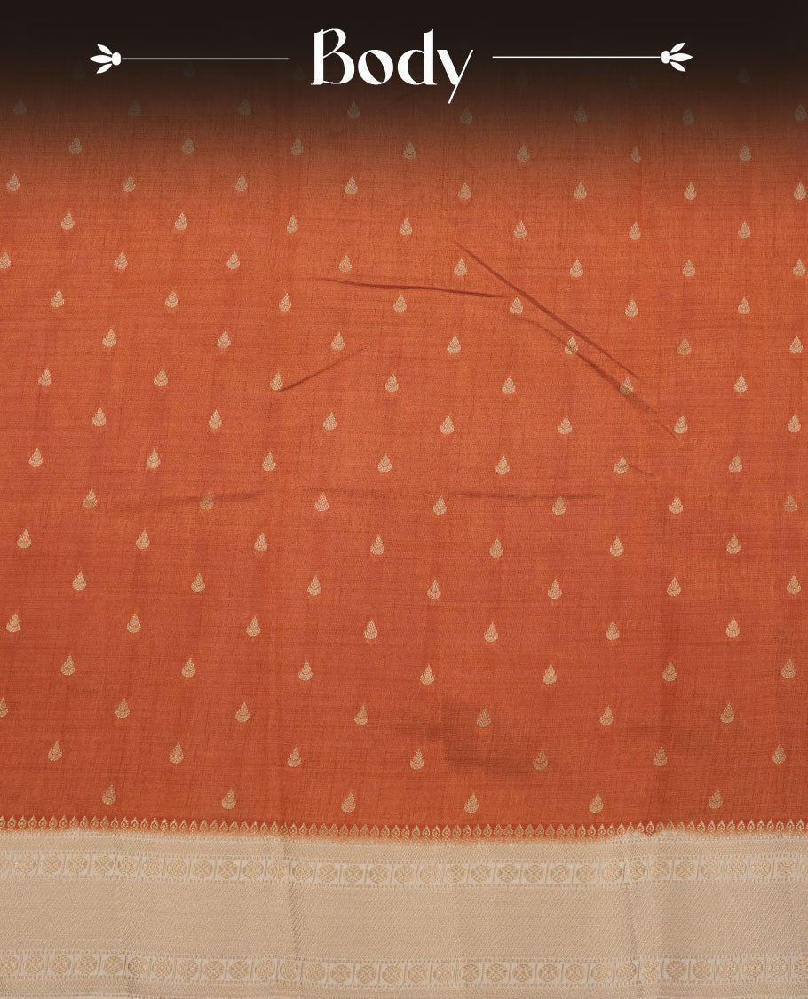 Orange colour tussar saree featuring litte gold zari motifs on body, contrast cream colour border and pallu with zari woven design, comes with matching blouse piece.