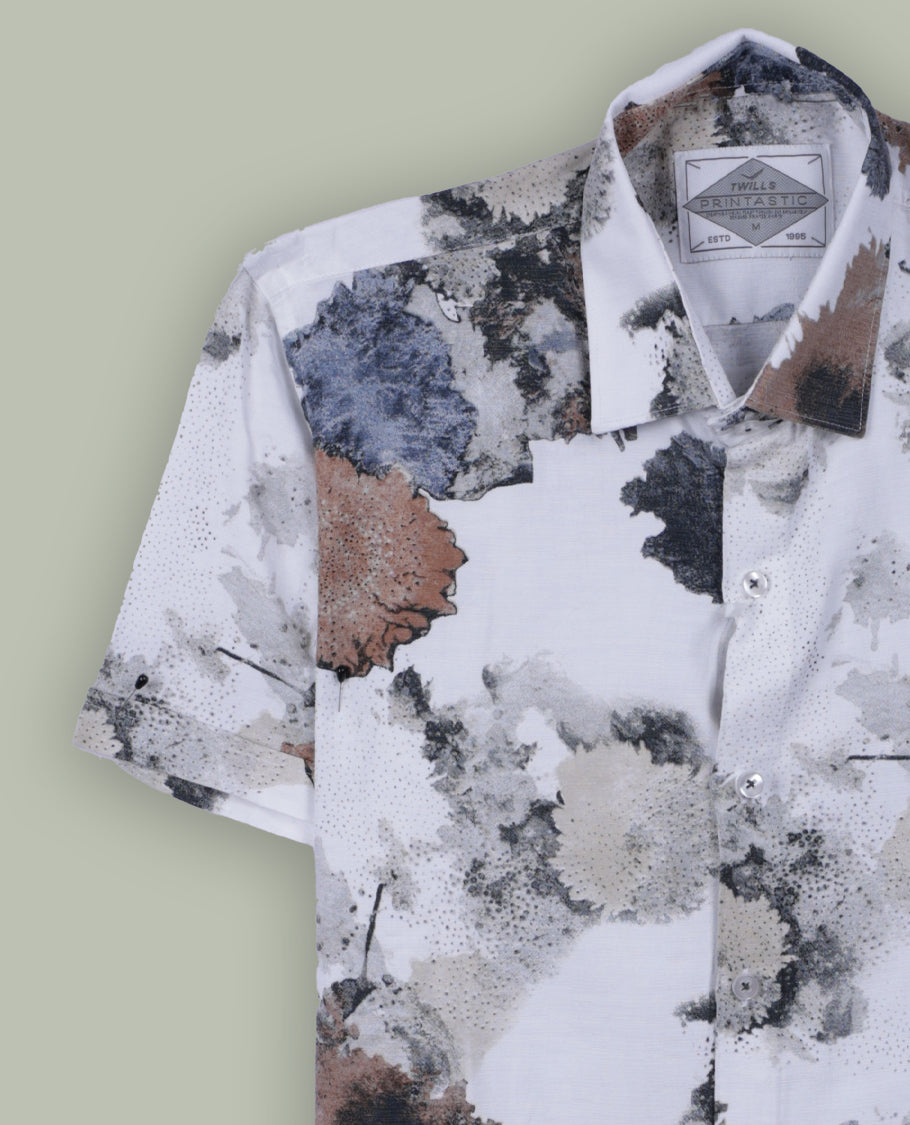 White colour short sleeve shirt features a rounded spread collar and a watercolor style floral print in brown, black, and blue & its ideal for both casual days and laid back evenings.