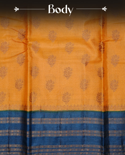 Mustard colour pure tussar banaras silk saree featuring gold zari motifs on body, highlighting contrast teal colour with zari border, paired with matching blouse piece.